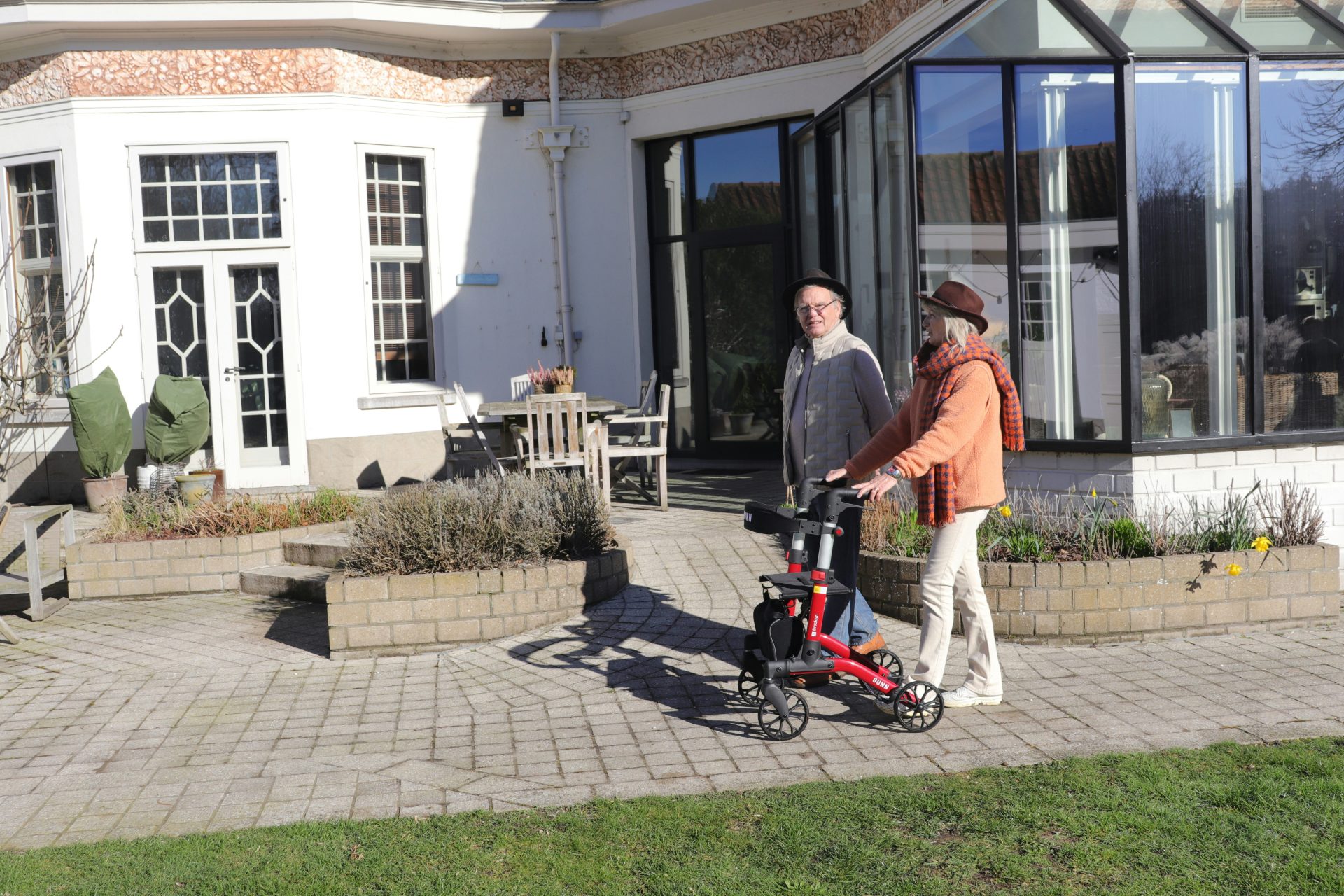Zwei Personen mit einem Rollator auf einer Terrasse